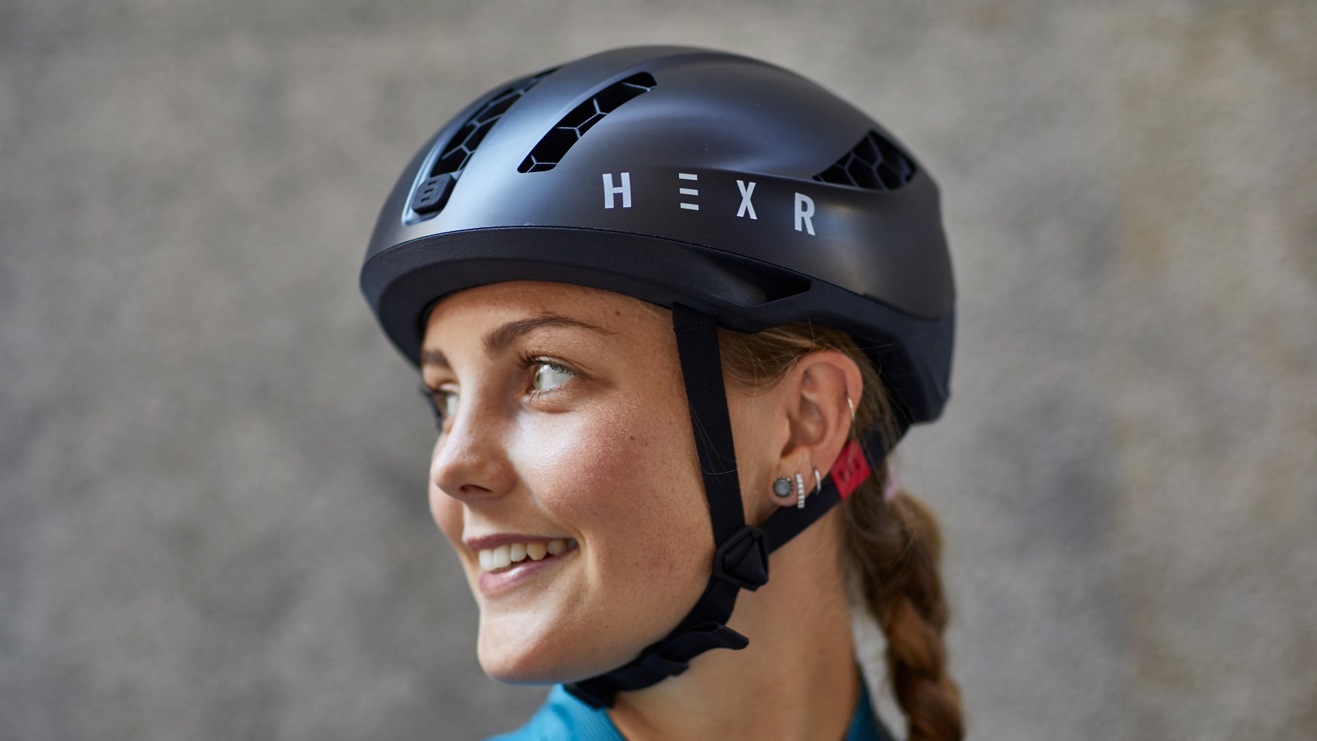 Woman smiling and wearing a HEXR helmet.